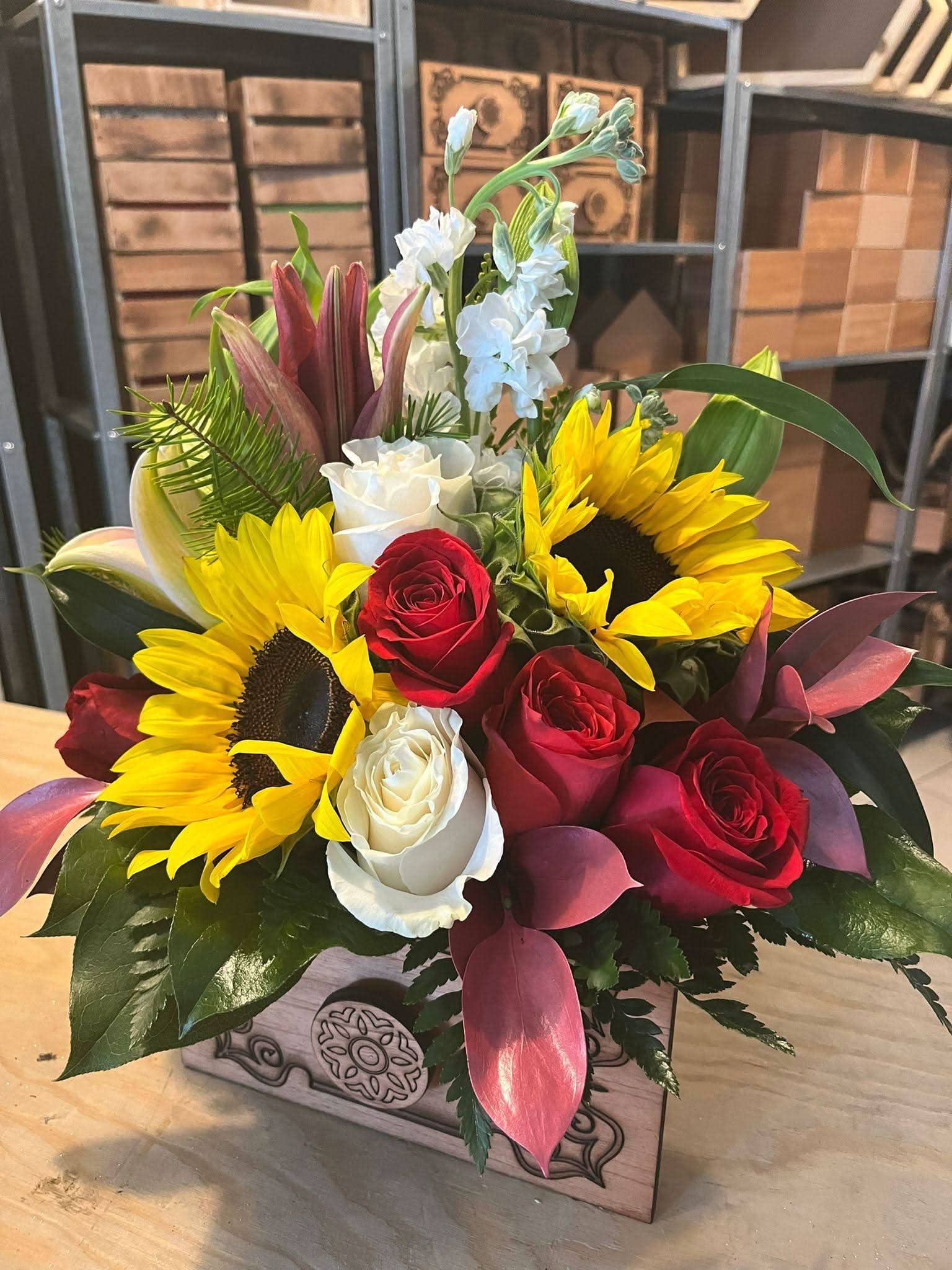 Arreglo floral con girasoles, rosas rojas y blancas en caja de madera decorativa