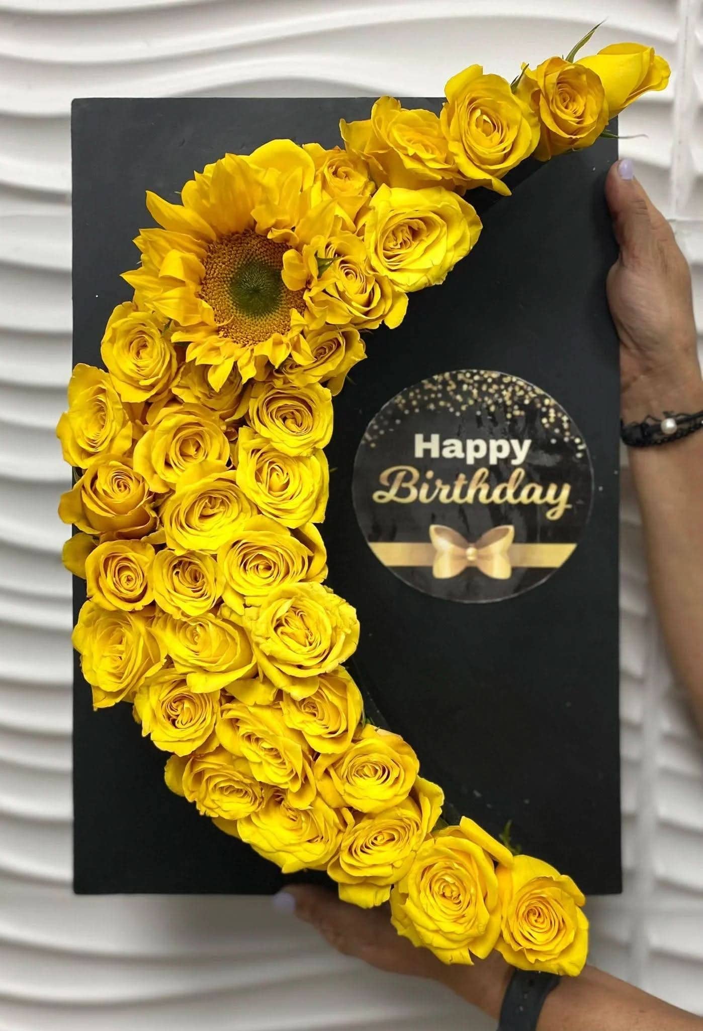 Arreglo floral de rosas y girasol amarillos en caja negra con mensaje de cumpleaños